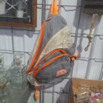 Gray backpack with orange accents hanging.