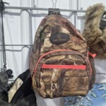 Camouflage backpack with red zipper on display.