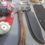 Axe with sheath and various items displayed.