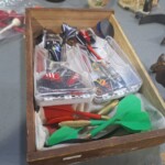 Box of assorted colorful darts and cases.