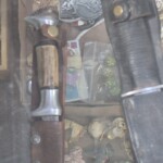 Knife with sheath and miscellaneous objects displayed.