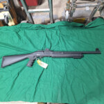 Black pump-action shotgun with yellow tag