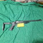 Long-barreled black rifle on green cloth