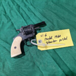 Black starter pistol with white grip