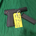 Handgun with tag and magazine on green cloth