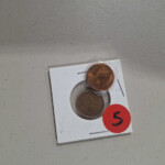Two coins in cardboard holder with red 5
