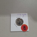 Silver coin in cardboard holder with red sticker