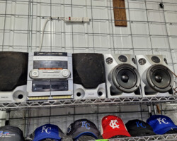 Stereo speakers and baseball caps on metal shelves