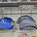 Blue KC baseball caps on metal shelf