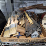 Box of paintbrushes and assorted hand tools
