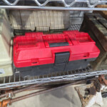 Red and black toolbox on metal shelf