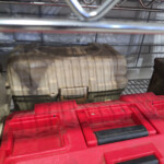 Red and beige plastic toolboxes on shelf