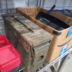 Rusty metal ammo box on shelf with skillet