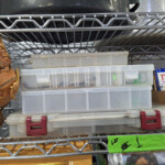 Stacked plastic tackle boxes on wire shelf
