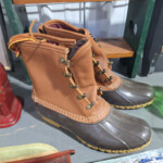 Pair of brown duck boots on shelf