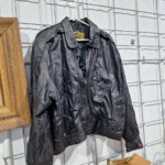Black leather jacket hanging on display rack
