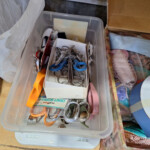 Plastic bin with sewing scissors and ribbons