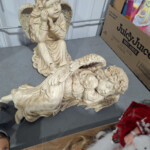 Sleeping cherub statue beside seated angel