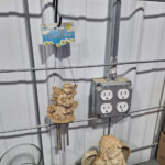 Hanging angel wind chime near industrial electrical outlet