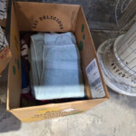 Cardboard box with folded towels next to heater