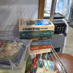 Stack of vintage military paperback books on shelf