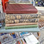 Stack of vintage children's readers on metal shelf