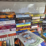Stacked paperback books on wire shelf