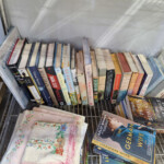 Shelf of stacked books and embroidered linens