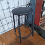 Black round metal stool with footrest