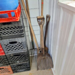 Shovels and pitchfork leaning in shed